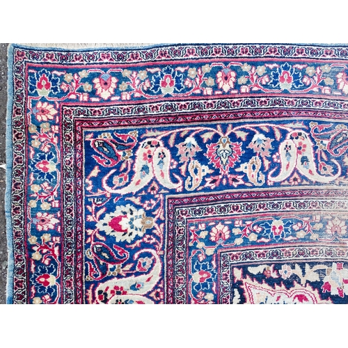 1507 - Carpet / Rug: A blue ground carpet with central cream and red floral motif bordered by scrolling fol... 