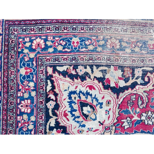 1507 - Carpet / Rug: A blue ground carpet with central cream and red floral motif bordered by scrolling fol... 