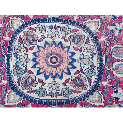 1507 - Carpet / Rug: A blue ground carpet with central cream and red floral motif bordered by scrolling fol... 