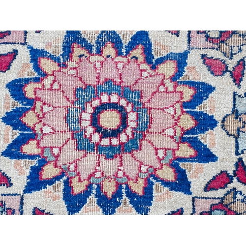 1507 - Carpet / Rug: A blue ground carpet with central cream and red floral motif bordered by scrolling fol... 