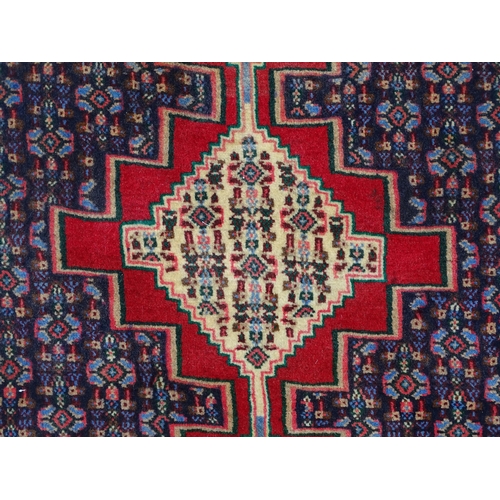 1514 - Carpet / Rug: A North West Persian Senneh runner the navy ground decorated with repeating geometric ... 