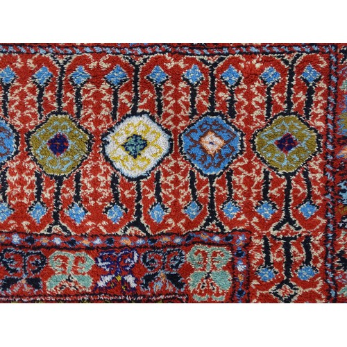 1504 - Carpet / Rug : A Moroccan red ground rug with central floral motif, decorated with birds and foliate... 