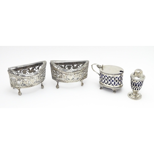 456 - A pair of white metal salts with griffin detail and clear glass liners. Together with a silver peppe... 