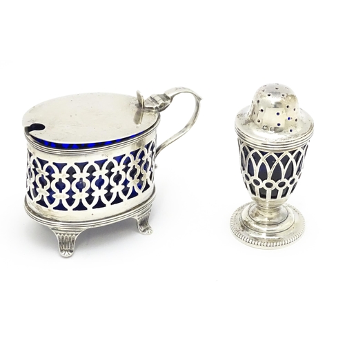 456 - A pair of white metal salts with griffin detail and clear glass liners. Together with a silver peppe... 