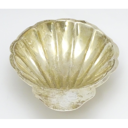 464 - A Mexican sterling silver butter dish of scallop shell form raised on three ball feet, maker Juvento... 