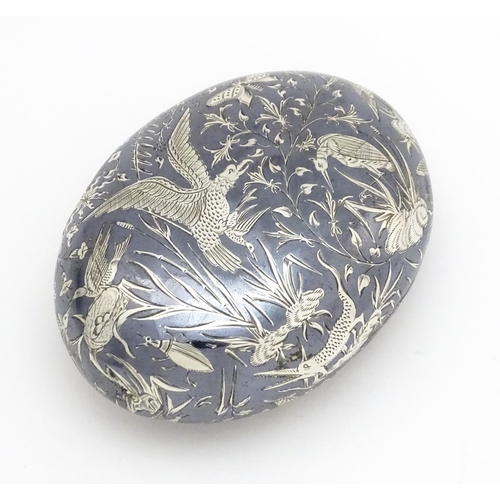 467 - A Continental white metal snuff box of oval form with niello decoration depicting birds, nests, inse... 