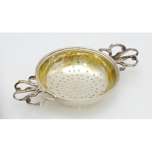 471 - A silver twin handled strainer and stand hallmarked London 1989, maker David R. Mills. Approx. 4 3/4... 