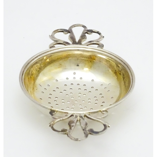 471 - A silver twin handled strainer and stand hallmarked London 1989, maker David R. Mills. Approx. 4 3/4... 