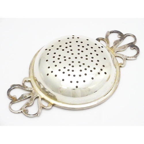 471 - A silver twin handled strainer and stand hallmarked London 1989, maker David R. Mills. Approx. 4 3/4... 