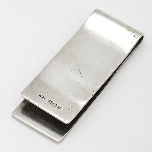 562 - A silver money clip with engine turned decoration hallmarked Birmingham 1980. Approx. 2