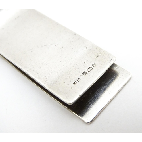 562 - A silver money clip with engine turned decoration hallmarked Birmingham 1980. Approx. 2