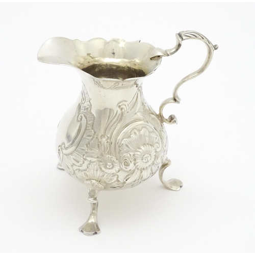 607 - A Geo III silver cream jug with engraved decoration, hallmarked London 1751. Approx. 3 1/4