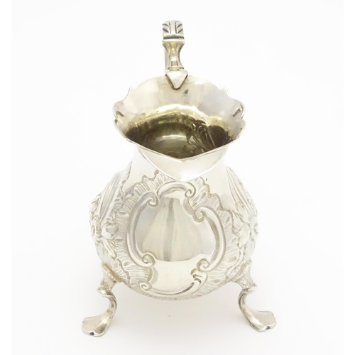 607 - A Geo III silver cream jug with engraved decoration, hallmarked London 1751. Approx. 3 1/4