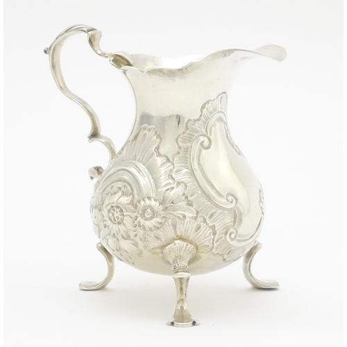 607 - A Geo III silver cream jug with engraved decoration, hallmarked London 1751. Approx. 3 1/4