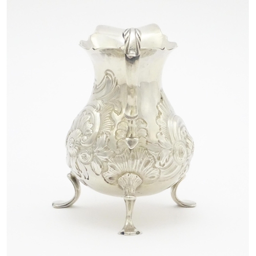 607 - A Geo III silver cream jug with engraved decoration, hallmarked London 1751. Approx. 3 1/4