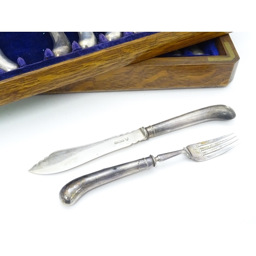 615 - An oak cased set of twelve silver fish knives and forks hallmarked Sheffield 1906, maker J & J Maxfi... 