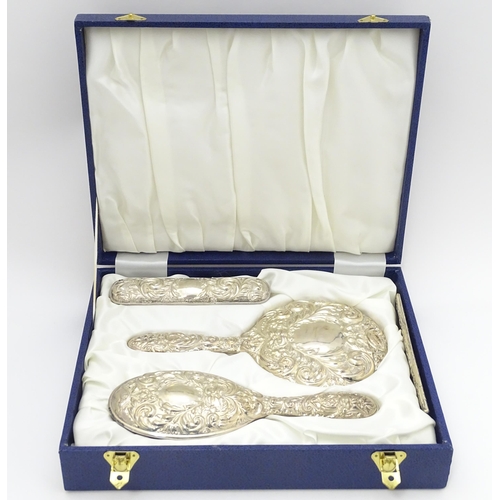 618 - A cased four piece dressing table set comprising silver hand mirror, brushes and comb. Hallmarked Bi... 