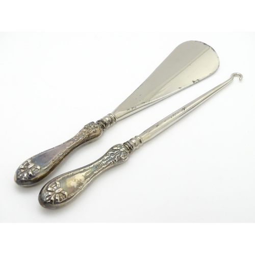 625 - A cased silver handled shoe horn and button hook with bow and swag detail, hallmarked Birmingham 192... 