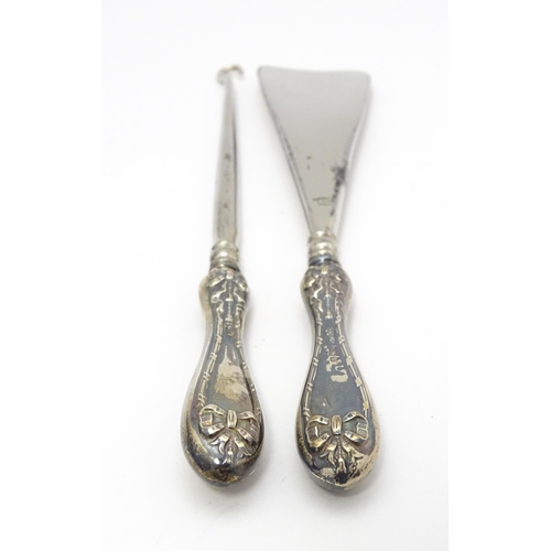 625 - A cased silver handled shoe horn and button hook with bow and swag detail, hallmarked Birmingham 192... 