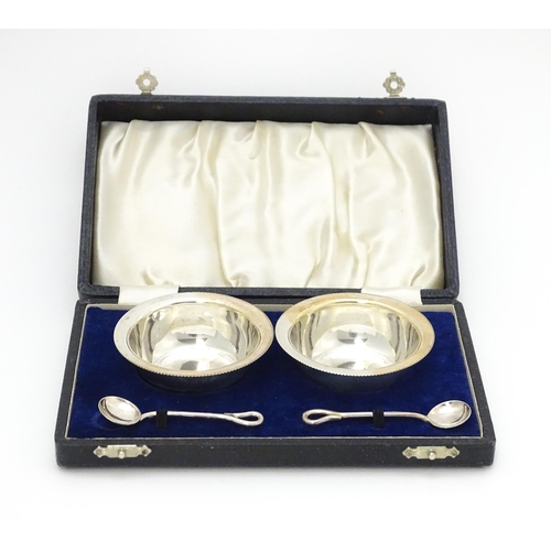 649 - A cased pair of silver salts and spoons hallmarked Birmingham 1942, maker Arnold E. Williams. Case a... 