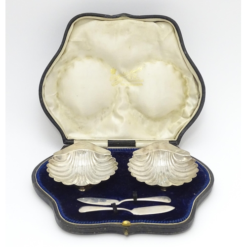 653 - A cased pair of silver butter dishes of scallop shell form, hallmarked Birmingham 1903 maker Minshul... 