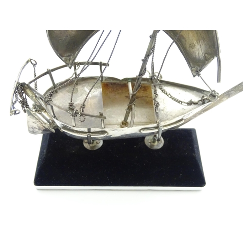 662A - A white metal model of a sailing boat on stand. Approx. 7 1/2