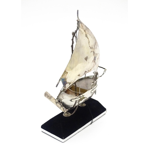 662A - A white metal model of a sailing boat on stand. Approx. 7 1/2