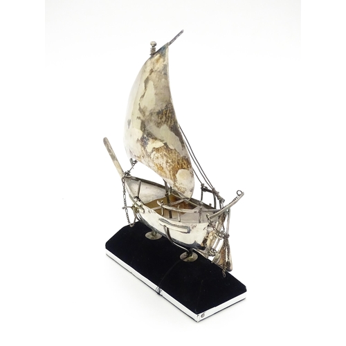 662A - A white metal model of a sailing boat on stand. Approx. 7 1/2