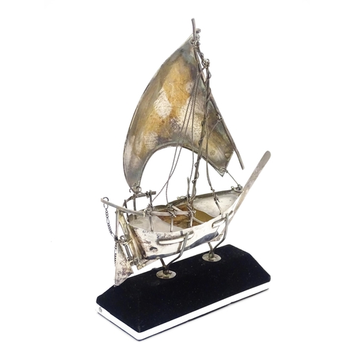 662A - A white metal model of a sailing boat on stand. Approx. 7 1/2