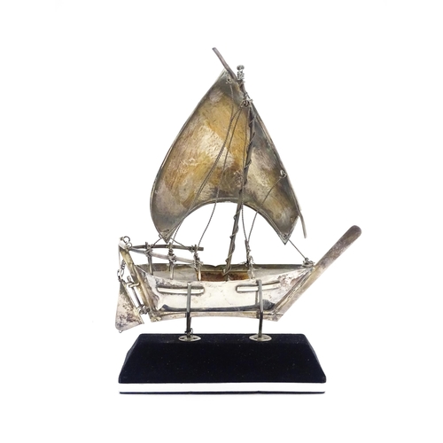 662A - A white metal model of a sailing boat on stand. Approx. 7 1/2