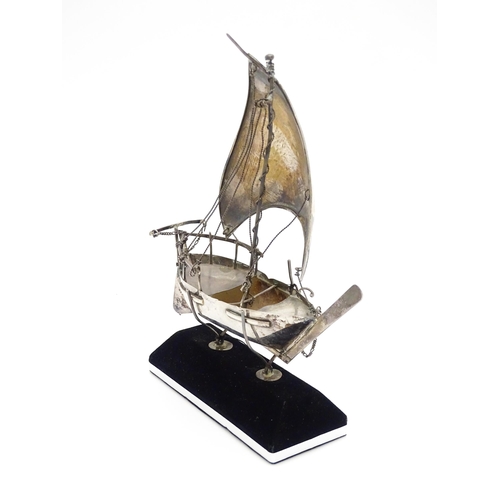 662A - A white metal model of a sailing boat on stand. Approx. 7 1/2