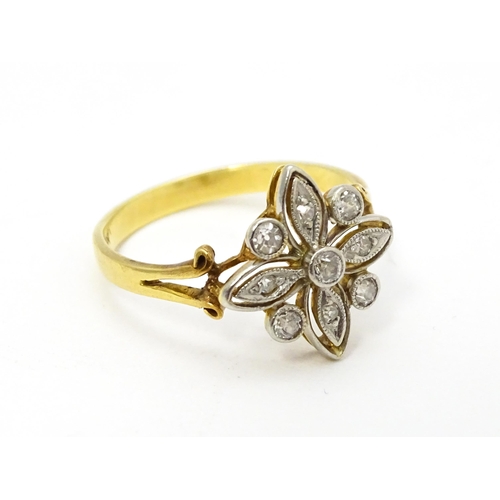 700 - An 18ct gold ring set with diamonds in a floral setting. Ring size approx. M