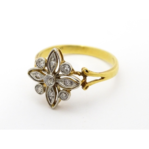 700 - An 18ct gold ring set with diamonds in a floral setting. Ring size approx. M