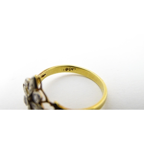 700 - An 18ct gold ring set with diamonds in a floral setting. Ring size approx. M