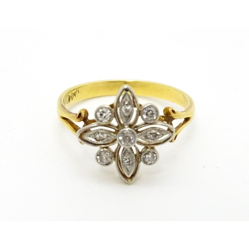 700 - An 18ct gold ring set with diamonds in a floral setting. Ring size approx. M