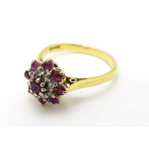 704 - An 18ct gold ring set with diamonds and red stones. Ring size approx. M 1/2