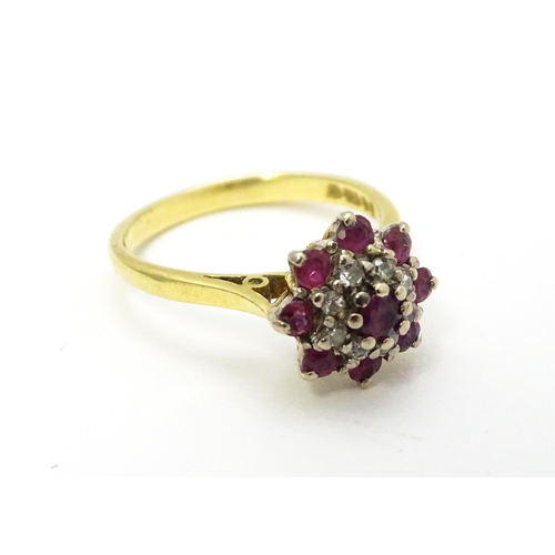 704 - An 18ct gold ring set with diamonds and red stones. Ring size approx. M 1/2