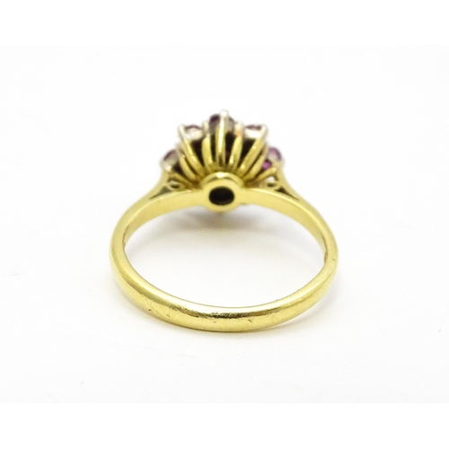 704 - An 18ct gold ring set with diamonds and red stones. Ring size approx. M 1/2