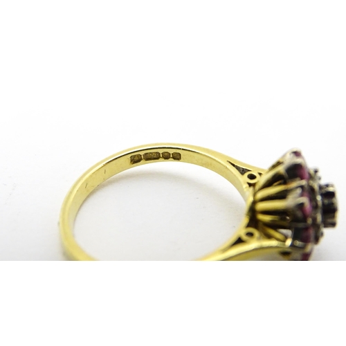 704 - An 18ct gold ring set with diamonds and red stones. Ring size approx. M 1/2