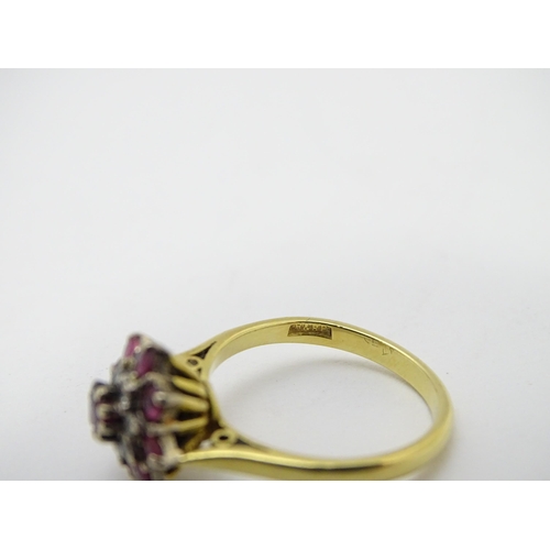 704 - An 18ct gold ring set with diamonds and red stones. Ring size approx. M 1/2