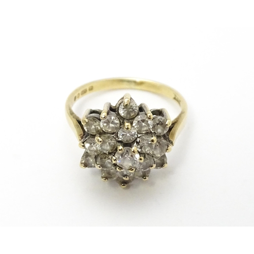 707 - A 9ct gold ring set with diamonds in a floral cluster setting. Ring size approx. M