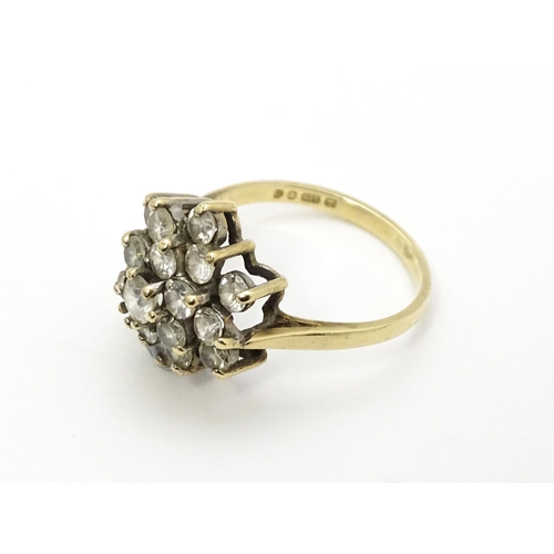 707 - A 9ct gold ring set with diamonds in a floral cluster setting. Ring size approx. M