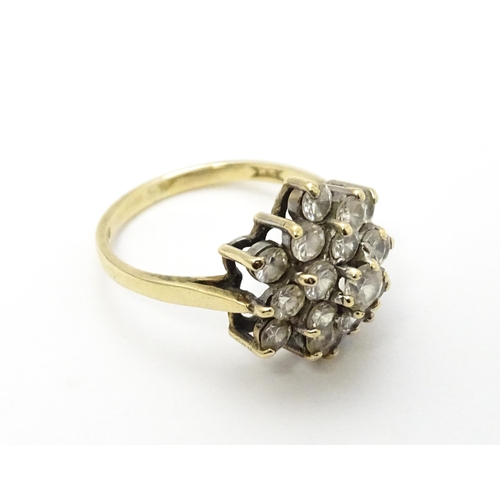 707 - A 9ct gold ring set with diamonds in a floral cluster setting. Ring size approx. M