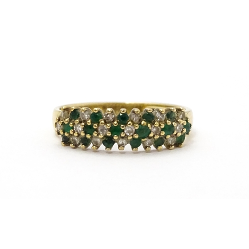 709 - A 9ct gold ring set with emeralds and diamonds. Ring size approx. K