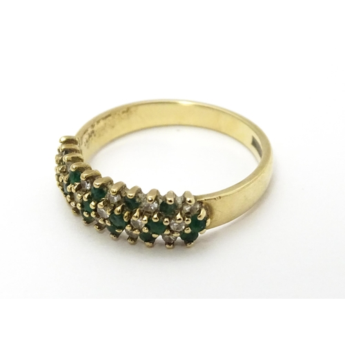 709 - A 9ct gold ring set with emeralds and diamonds. Ring size approx. K