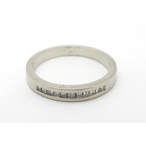 710 - A platinum ring set with 11 diamonds in a linear setting. Ring size approx. M 1/2