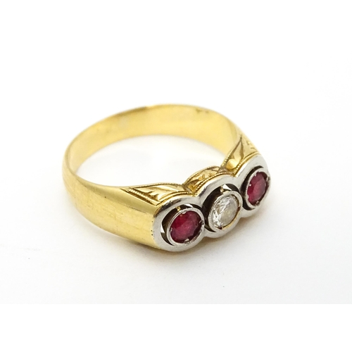 711 - A yellow gold ring set with central diamond  flanked by rubies. Ring size approx. P