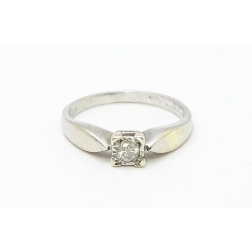 712 - A 9ct white gold ring set with a diamond solitaire. Ring size approx. K