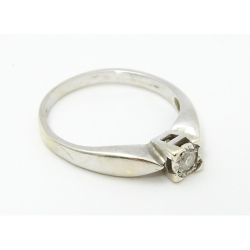 712 - A 9ct white gold ring set with a diamond solitaire. Ring size approx. K