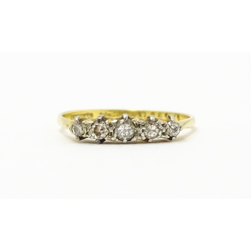 715 - An 18ct gold ring with 5 platinum set graduated diamonds.  Ring size approx P